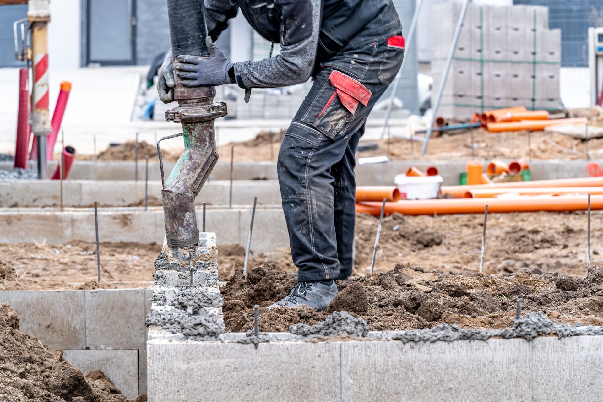 A construction worker is using a hammer to drill a hole in the ground.