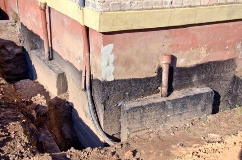 Foundation repair in progress by digging around the foundation