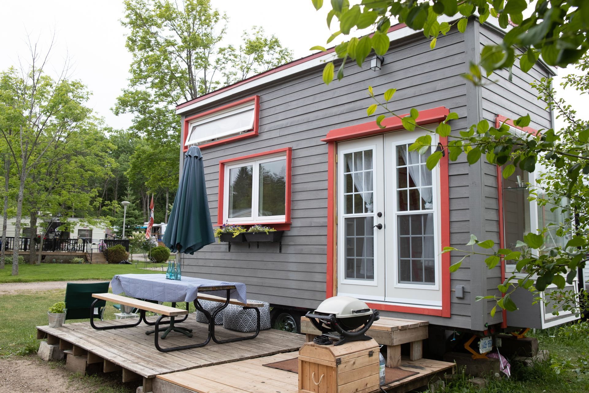 graues Containerhaus mit roten Fensterrahmen