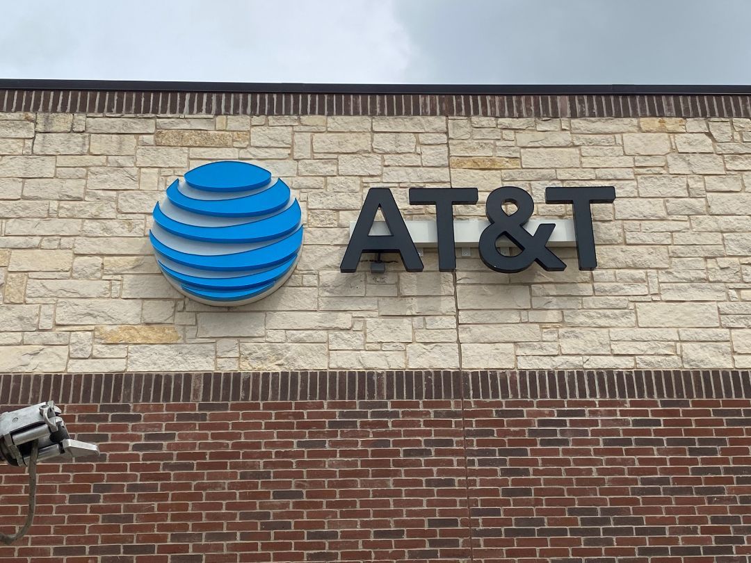 The at & t logo is on the side of a brick building.