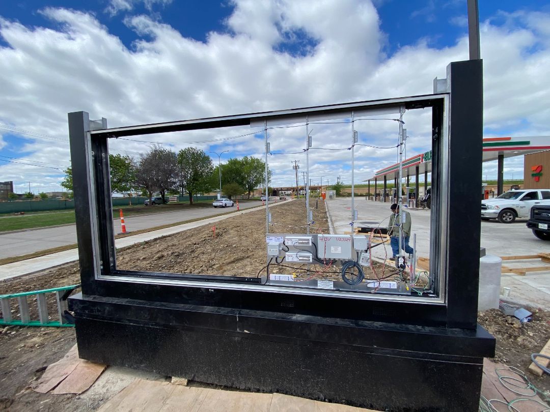 A fence is being built in front of a gas station.