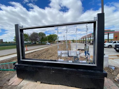 A fence is being built in front of a gas station.