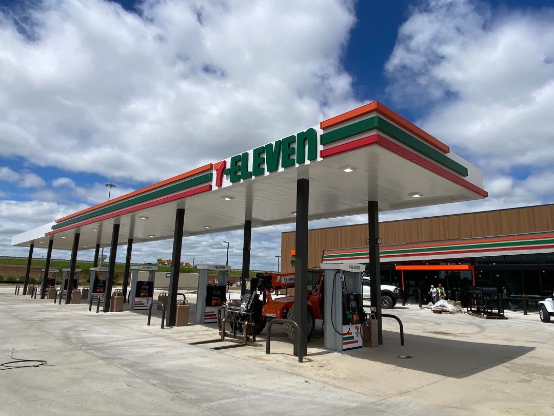 A 7 eleven gas station with a truck parked in front of it.