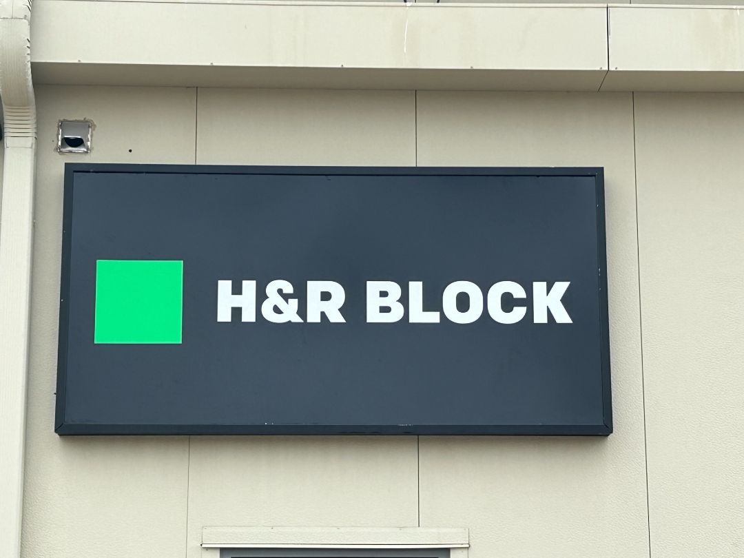 A sign on the side of a building that says h & r block