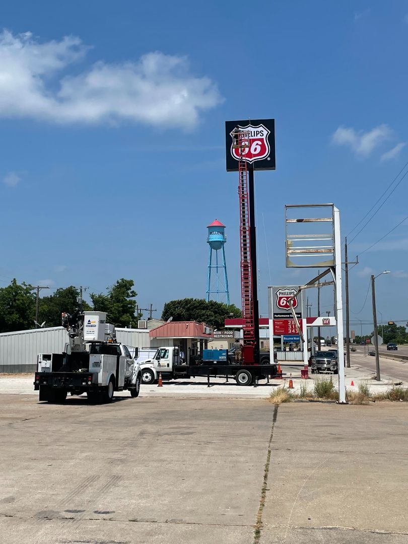 A sign for route 66 is being installed at a gas station