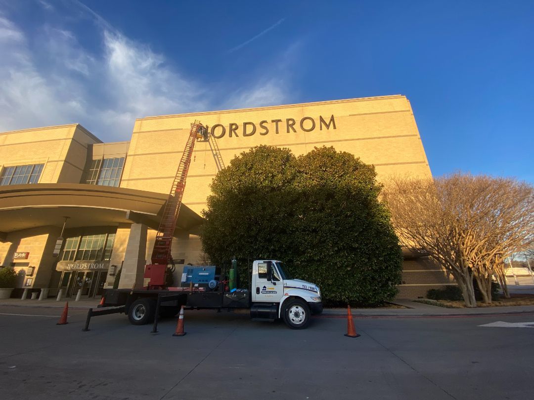 A truck is parked in front of a nordstrom store.
