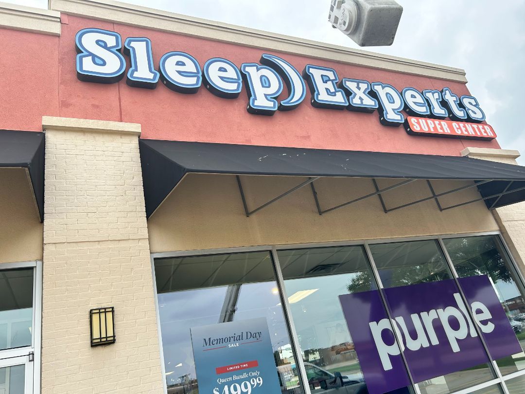 The front of a sleep experts store with purple signs