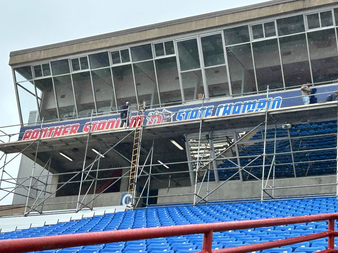A stadium with blue seats and scaffolding on the side of it