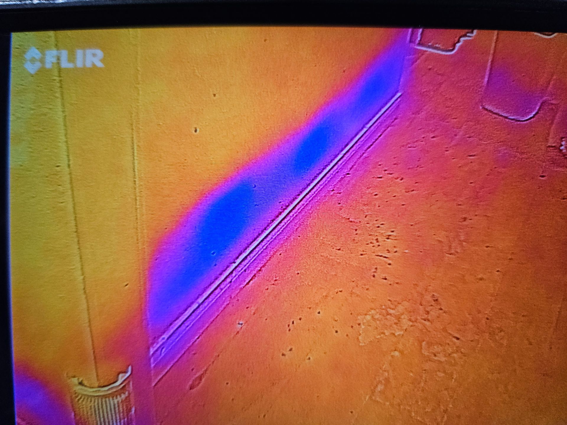 Infrared image displaying moisture buildup within a wall