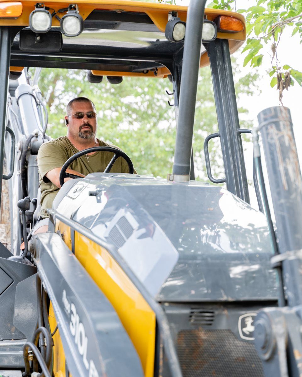 A man is driving a john deere tractor