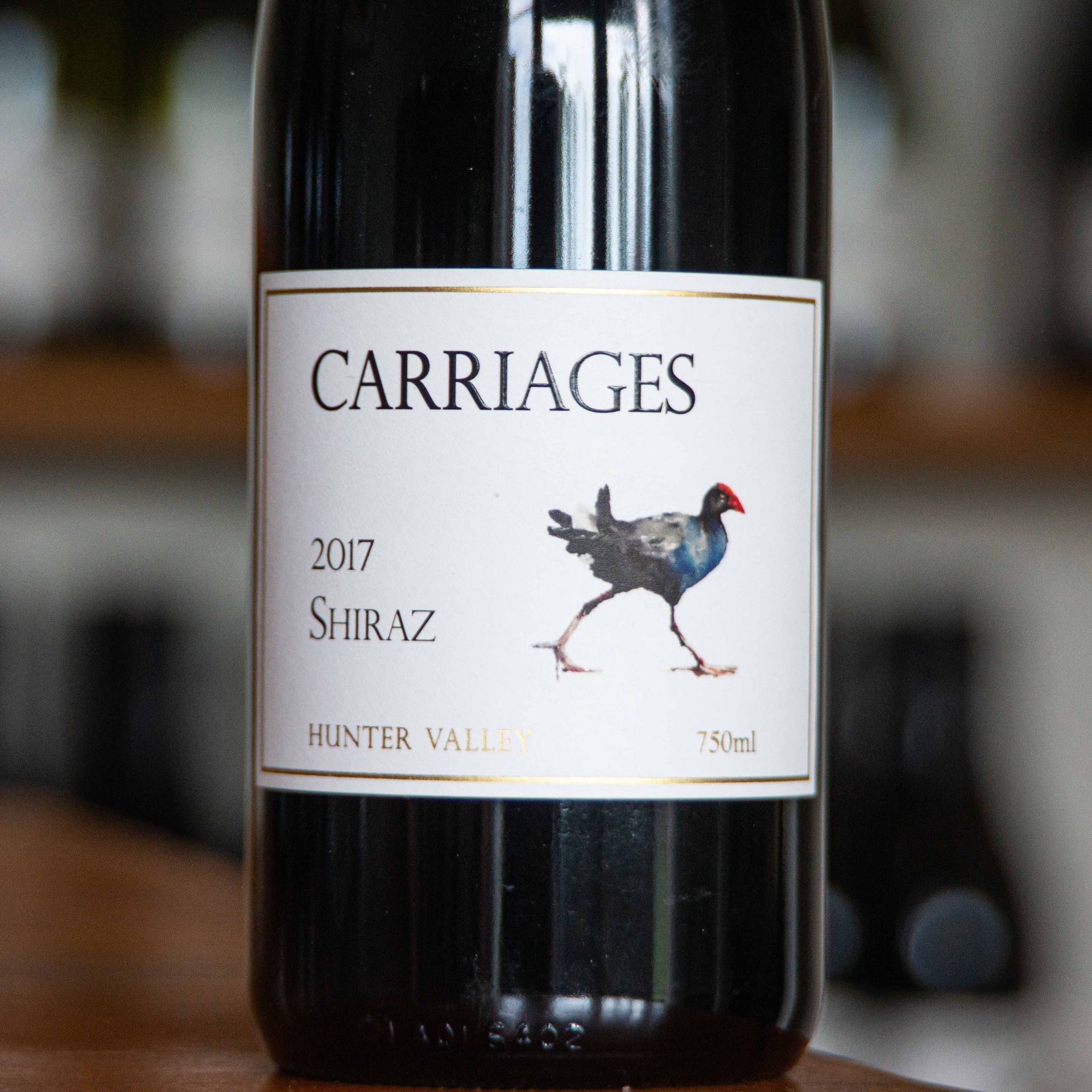 Close up image of Welly's Block Shiraz next to two wine glasses.