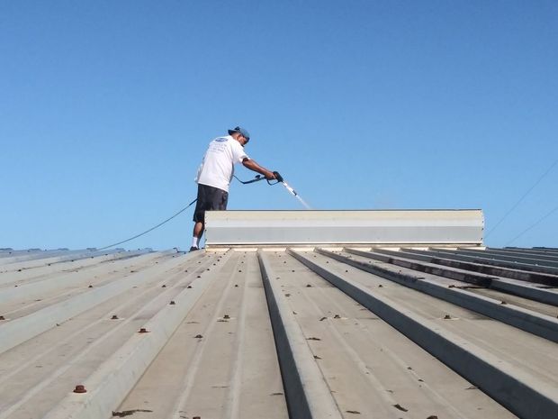 Image showing RNR Pressure cleaning washing a commercial metal roof using a soft wash.