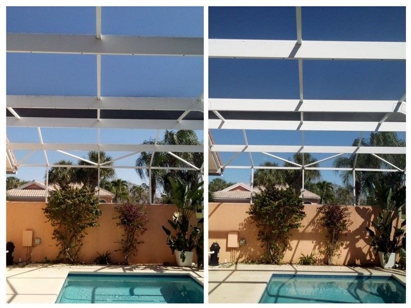 Image of a pool screen cleaning. You can see a Jensen Beach house with a pool cage that has been washed. 