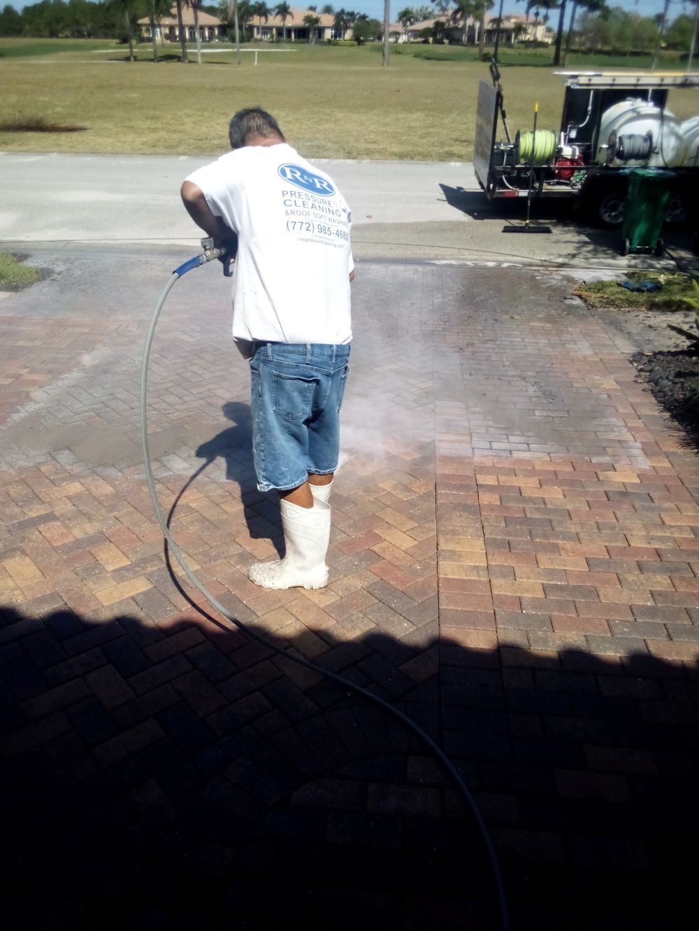 Image of RNR Pressure cleaning washing a sidewalk and paver stone driveway.