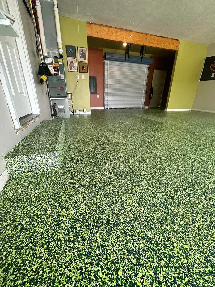 Indoor hallway with green speckled floor, yellow walls, and a closed metal shutter door.
