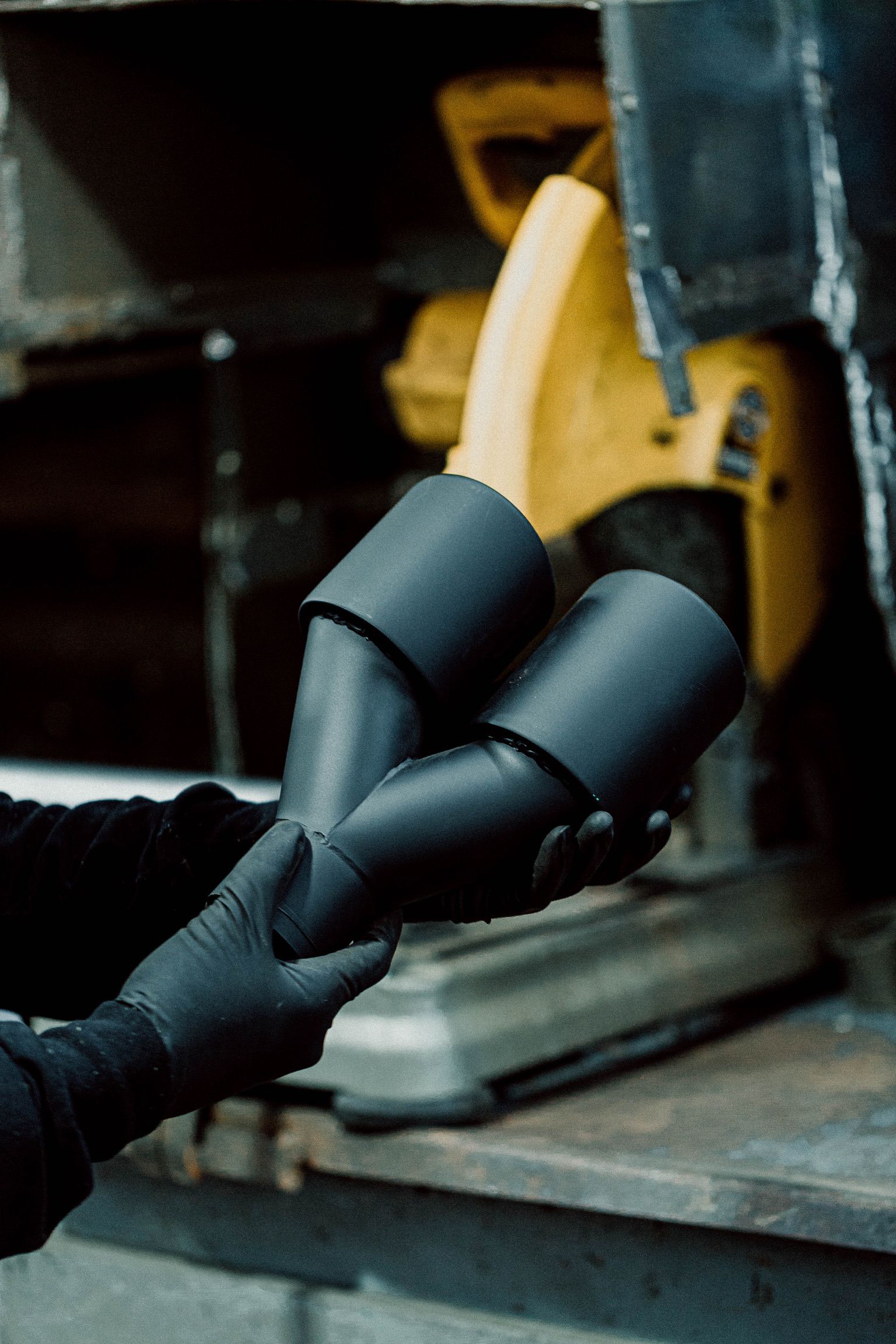 Une personne portant des gants noirs tient un morceau de métal.