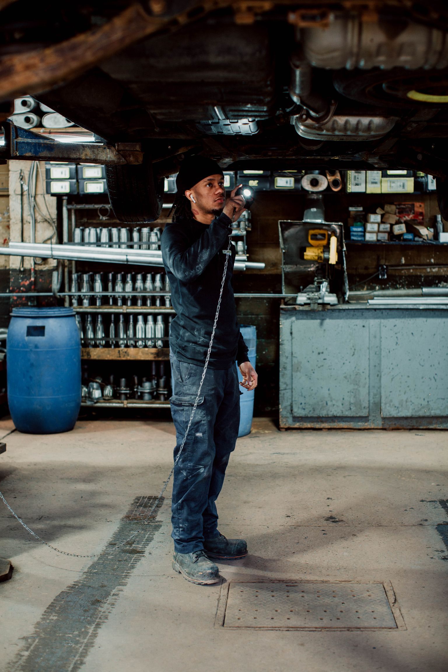 Un homme est debout dans un garage tenant un tuyau.