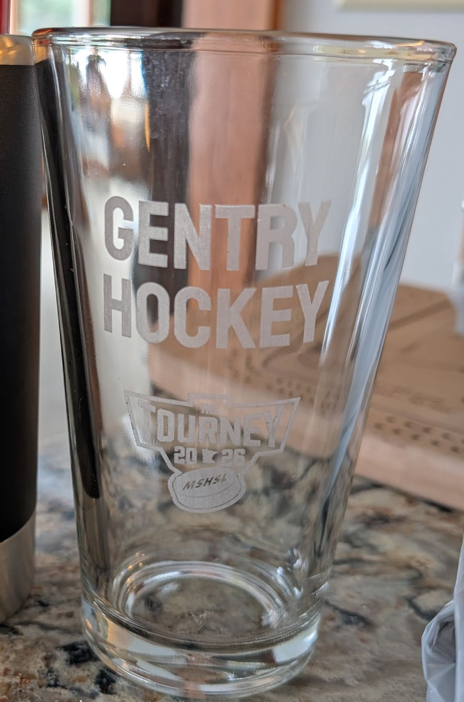 Tall crystal glass with logo.
