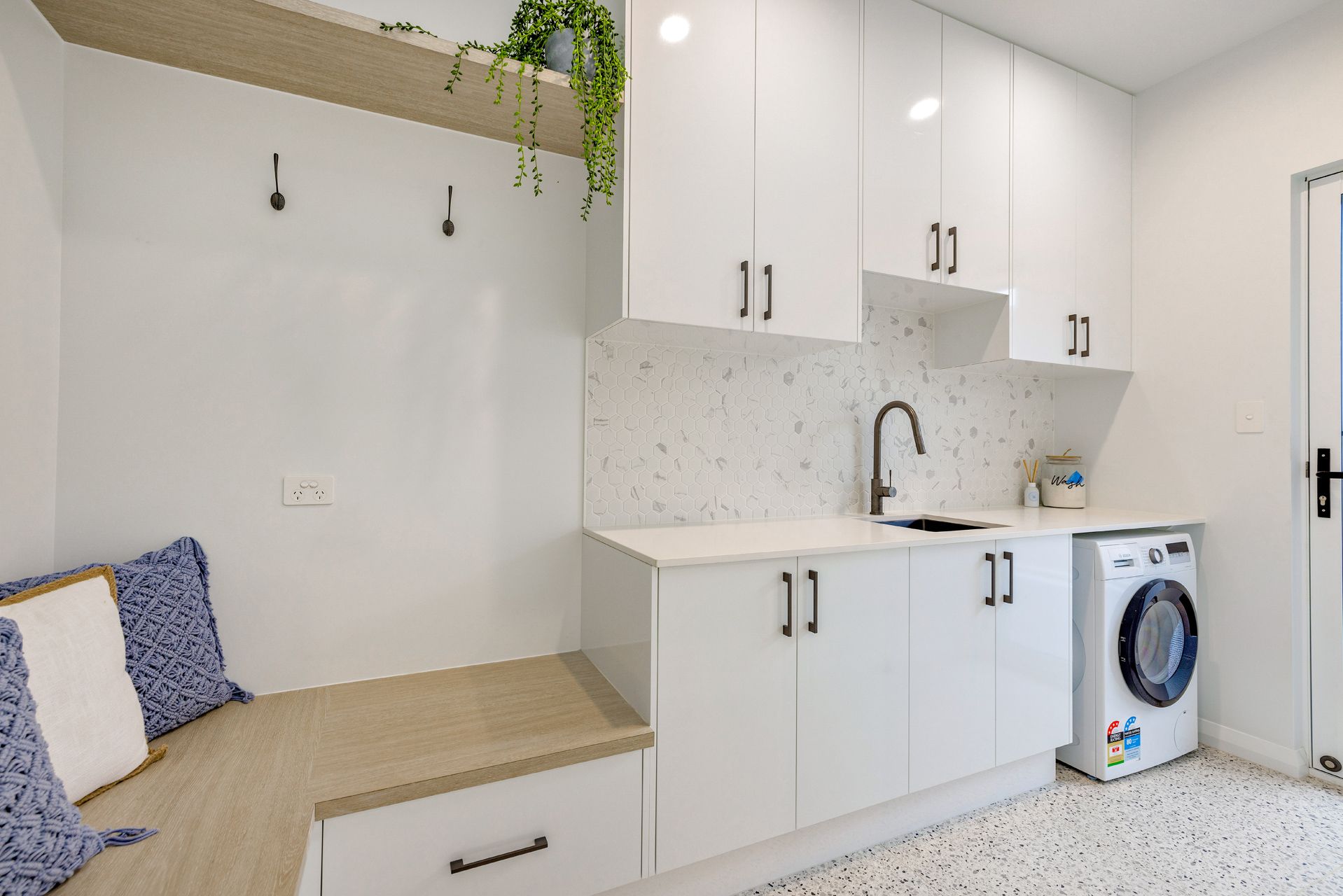 A Modern Laundry Room With White Cabinets — Ashlee Jones Homes in Gordonvale, QLD