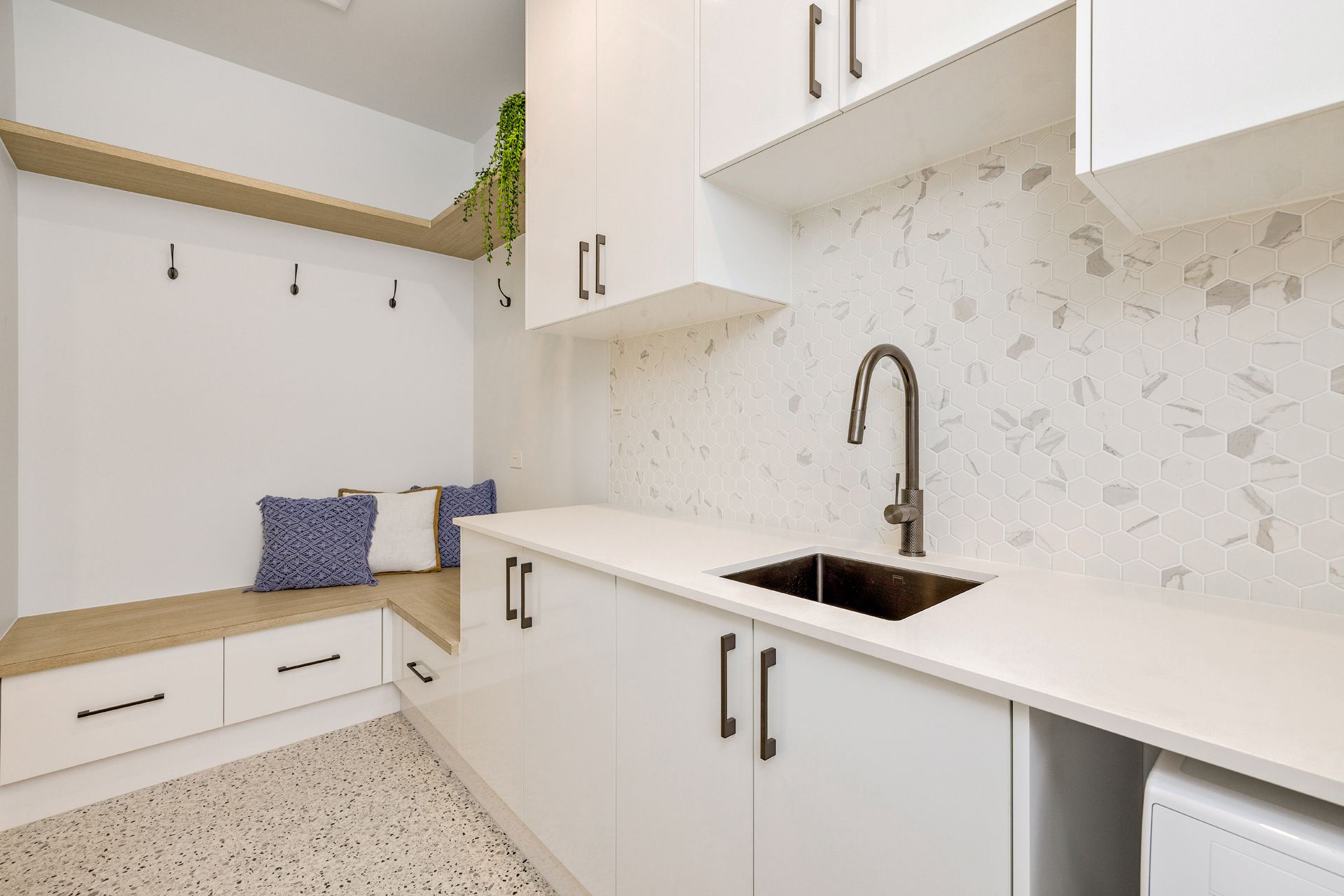 A Modern White Laundry Room Featuring a Built-in Bench — Ashlee Jones Homes in Gordonvale, QLD