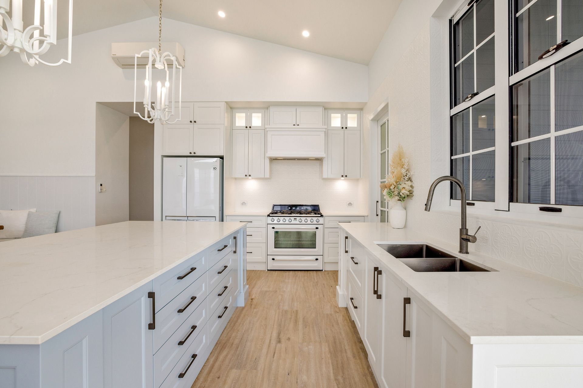 A Bright, Modern Kitchen Features a Large White Island — Ashlee Jones Homes in Gordonvale, QLD