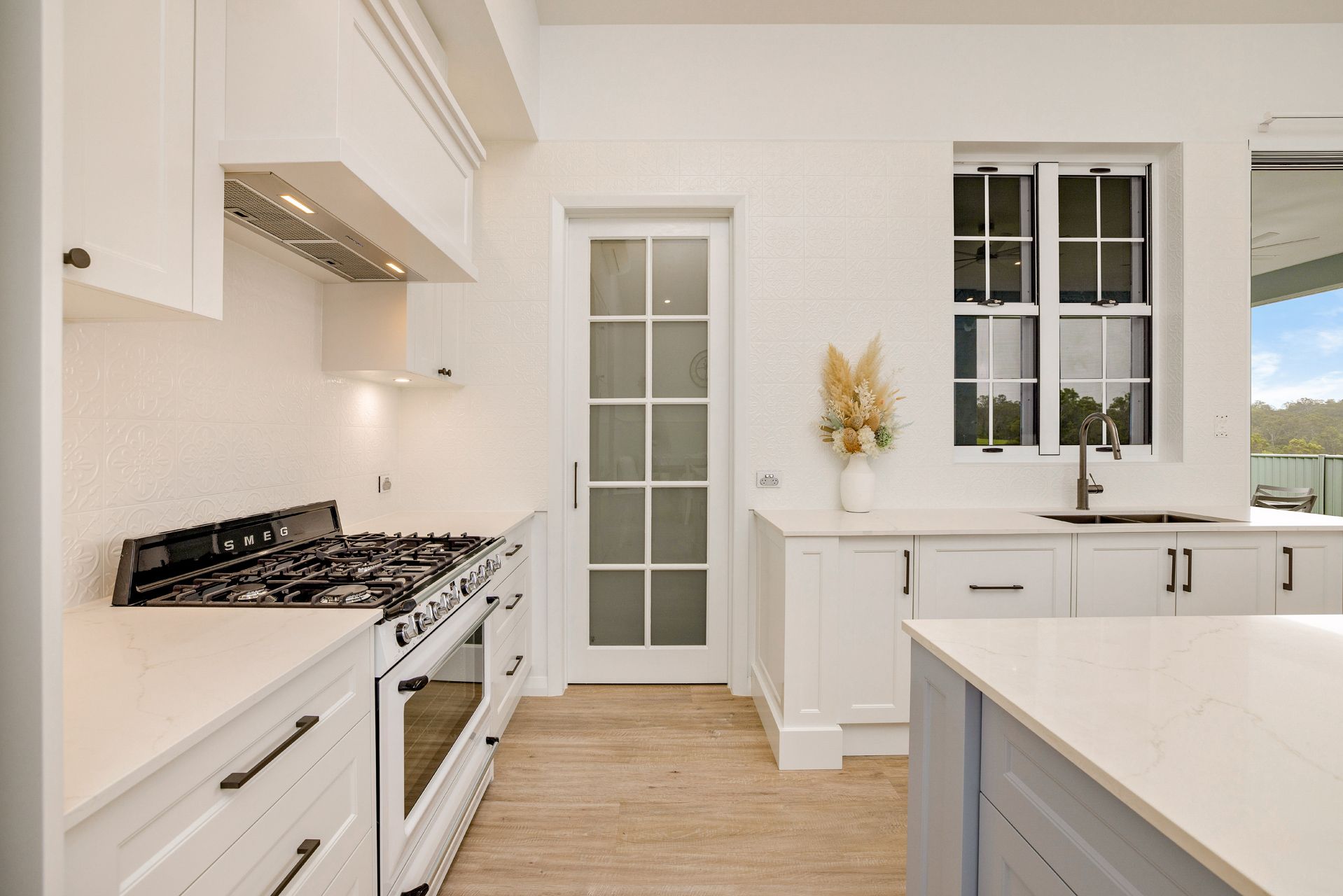 A Bright, Modern Kitchen Featuring White Cabinetry — Ashlee Jones Homes in Gordonvale, QLD