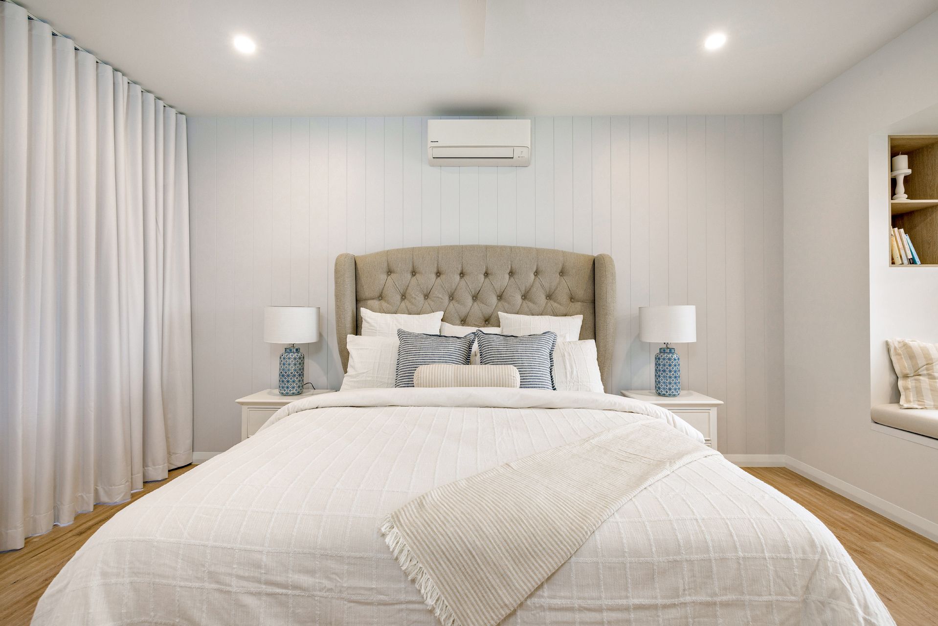 A Modern, Neutrally Toned Bedroom Featuring a Tufted Beige Headboard — Ashlee Jones Homes in Gordonvale, QLD