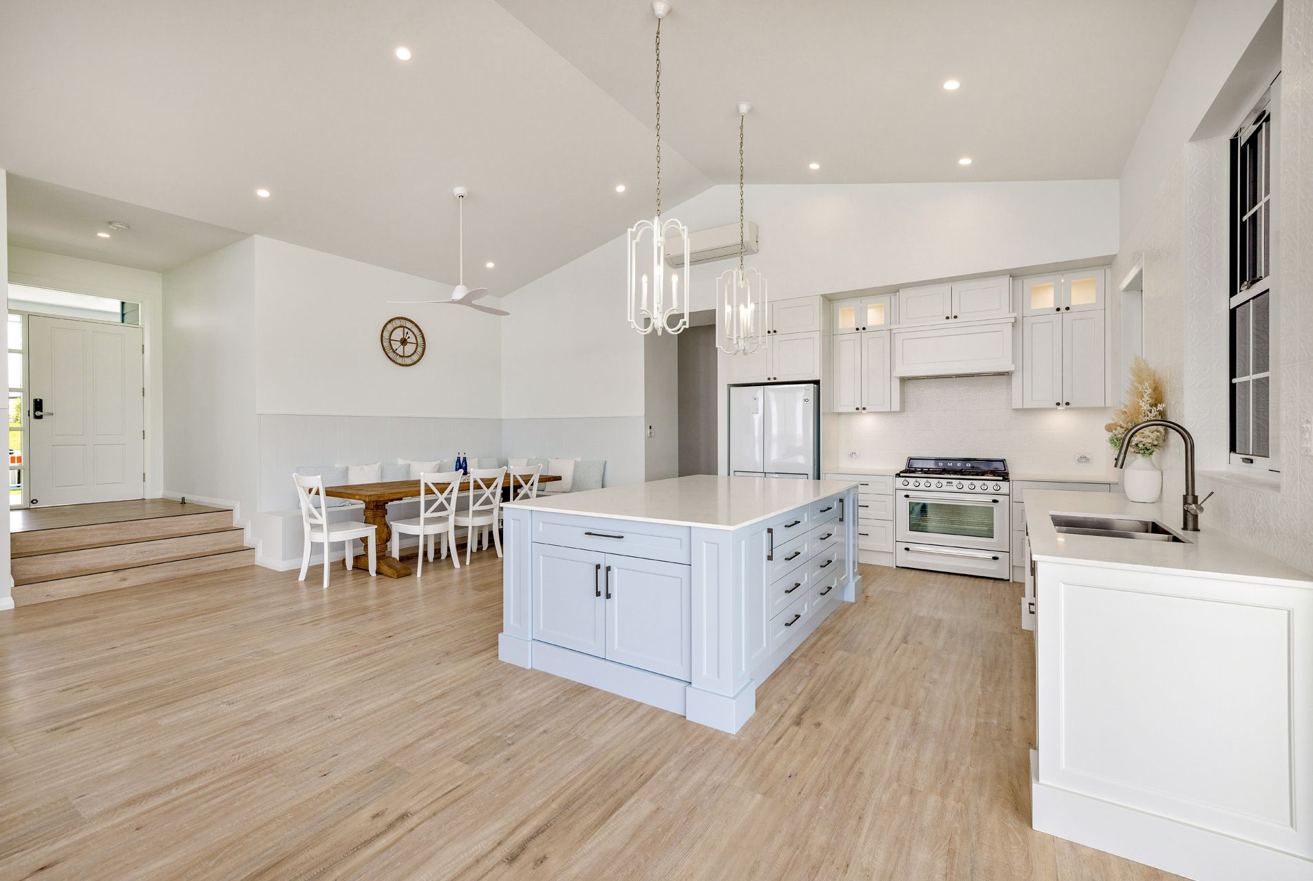 A Bright Kitchen With White Cabinets, a Light Blue Center Island — Ashlee Jones Homes in Gordonvale, QLD