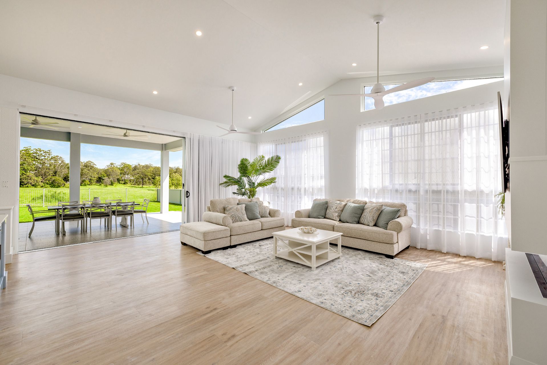 A Bright, Open-plan Living Room With Light Wood Floors — Ashlee Jones Homes in Gordonvale, QLD