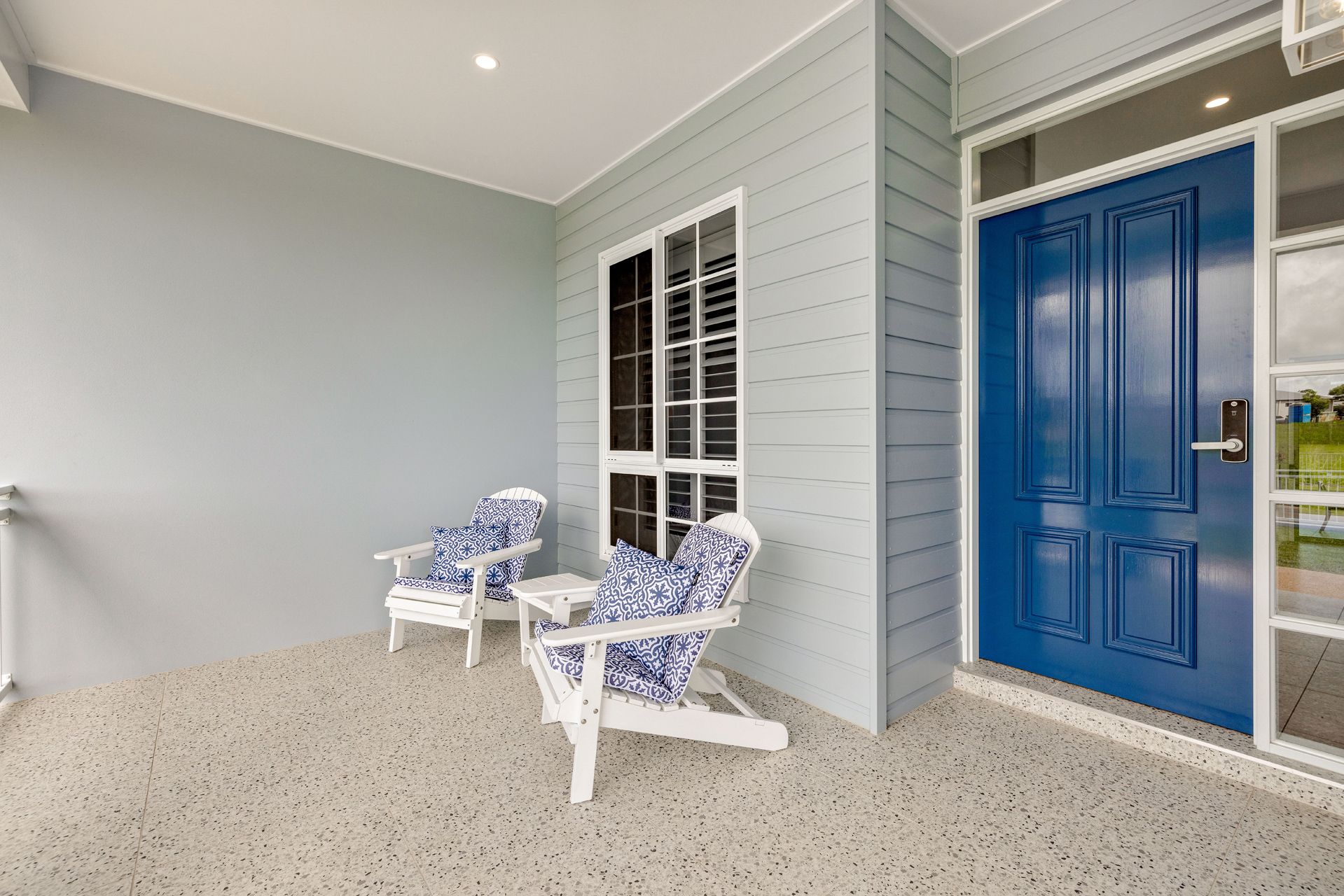 A Porch With Two White Chairs, Patterned Blue Cushion — Ashlee Jones Homes in Gordonvale, QLD
