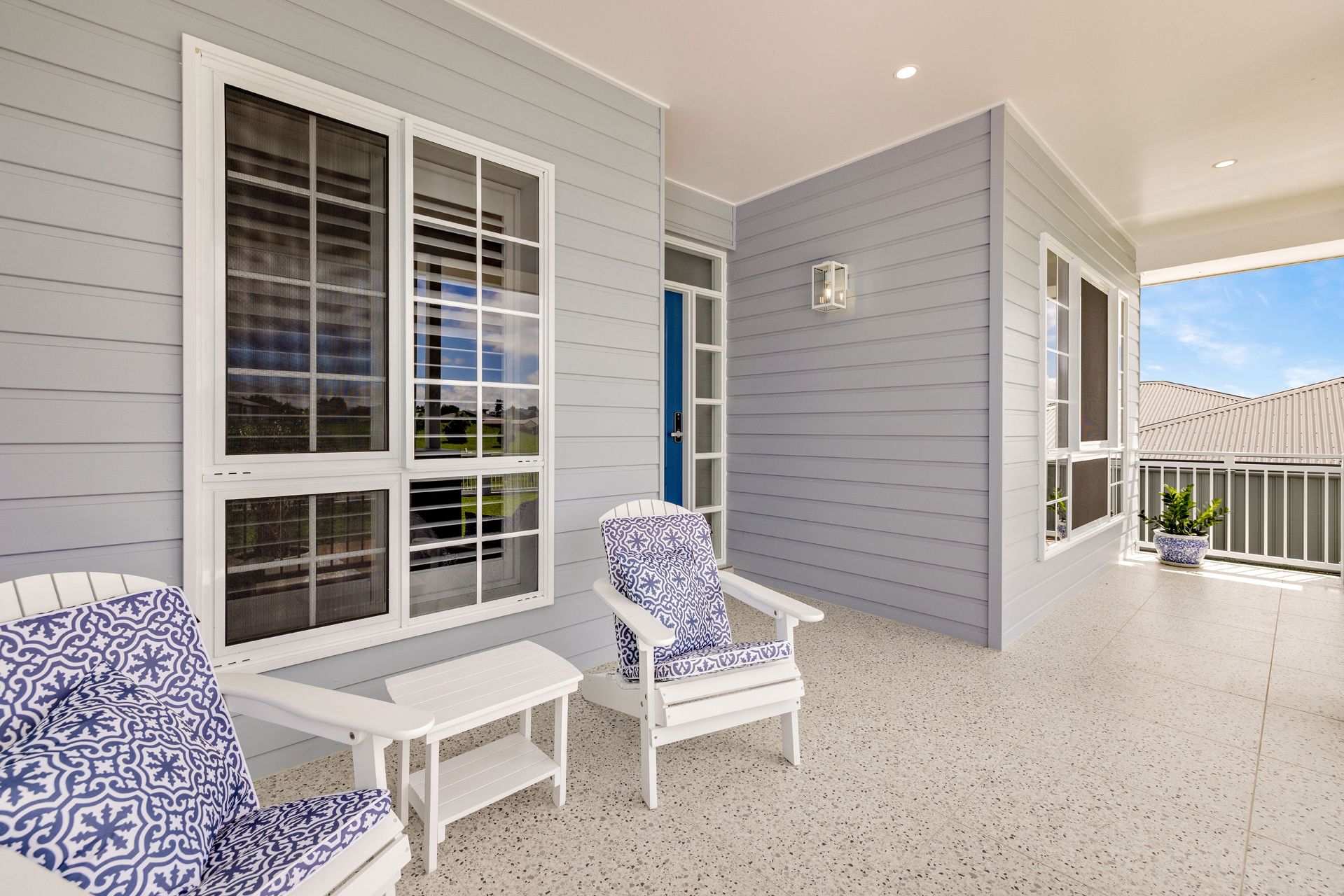 A Covered Porch With Light Gray Horizontal Siding, Two White Chairs — Ashlee Jones Homes in Gordonvale, QLD