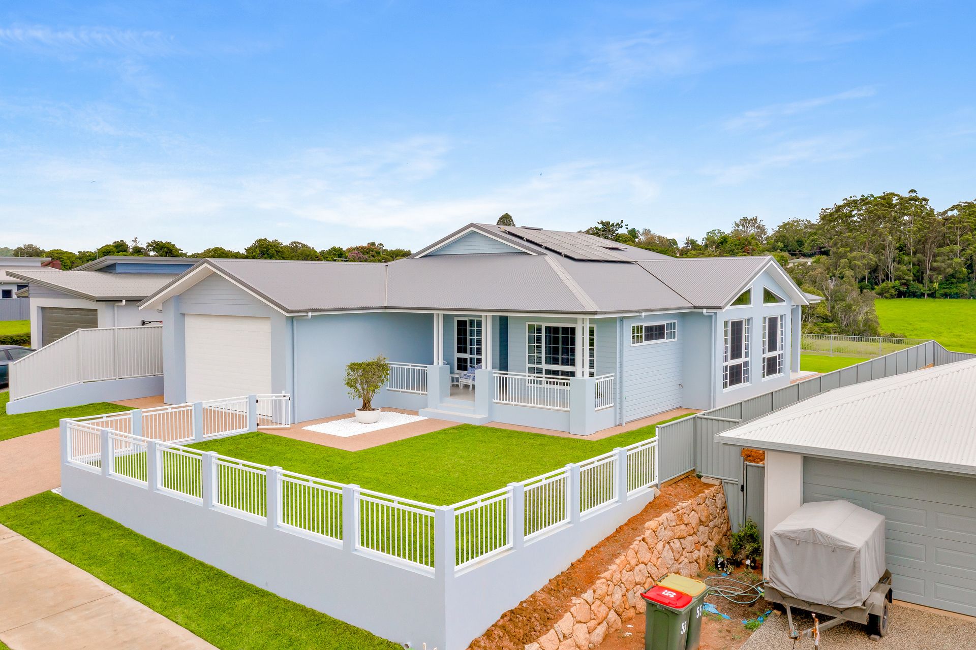 A Light Blue Single-story House With a White Fence — Ashlee Jones Homes in Gordonvale, QLD