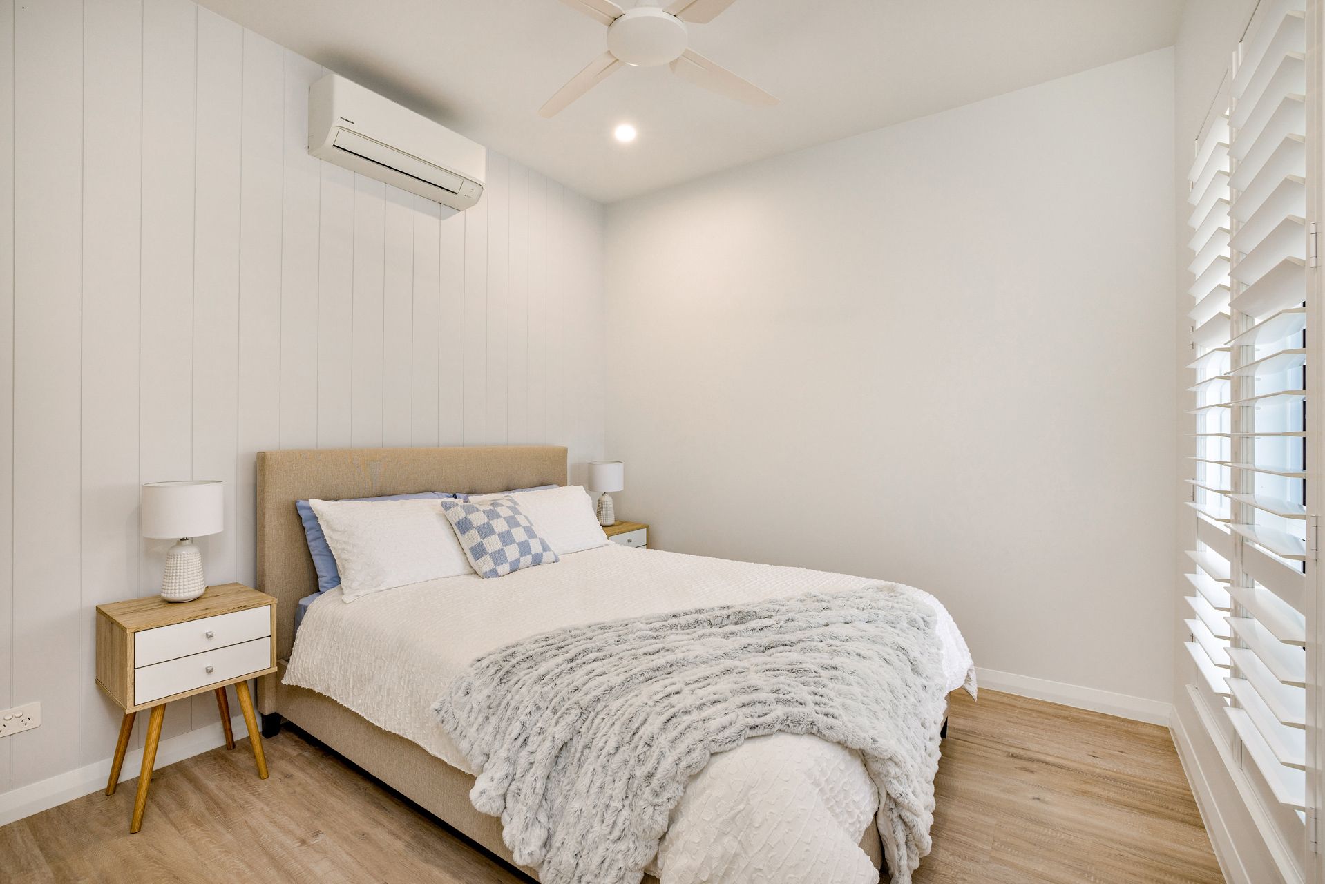 A Bright, Modern Bedroom Featuring a Bed With White Bedding — Ashlee Jones Homes in Gordonvale, QLD