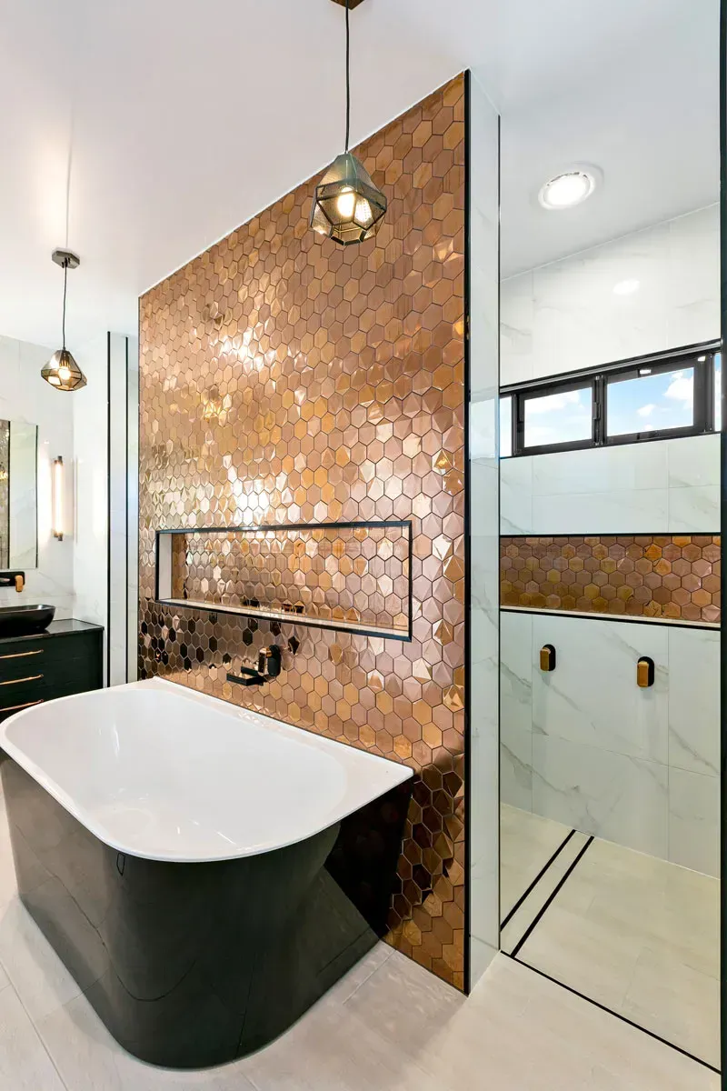 A Bathroom With a Bathtub, Sink, Shower and Copper Tiles — Ashlee Jones Homes in Gordonvale, QLD