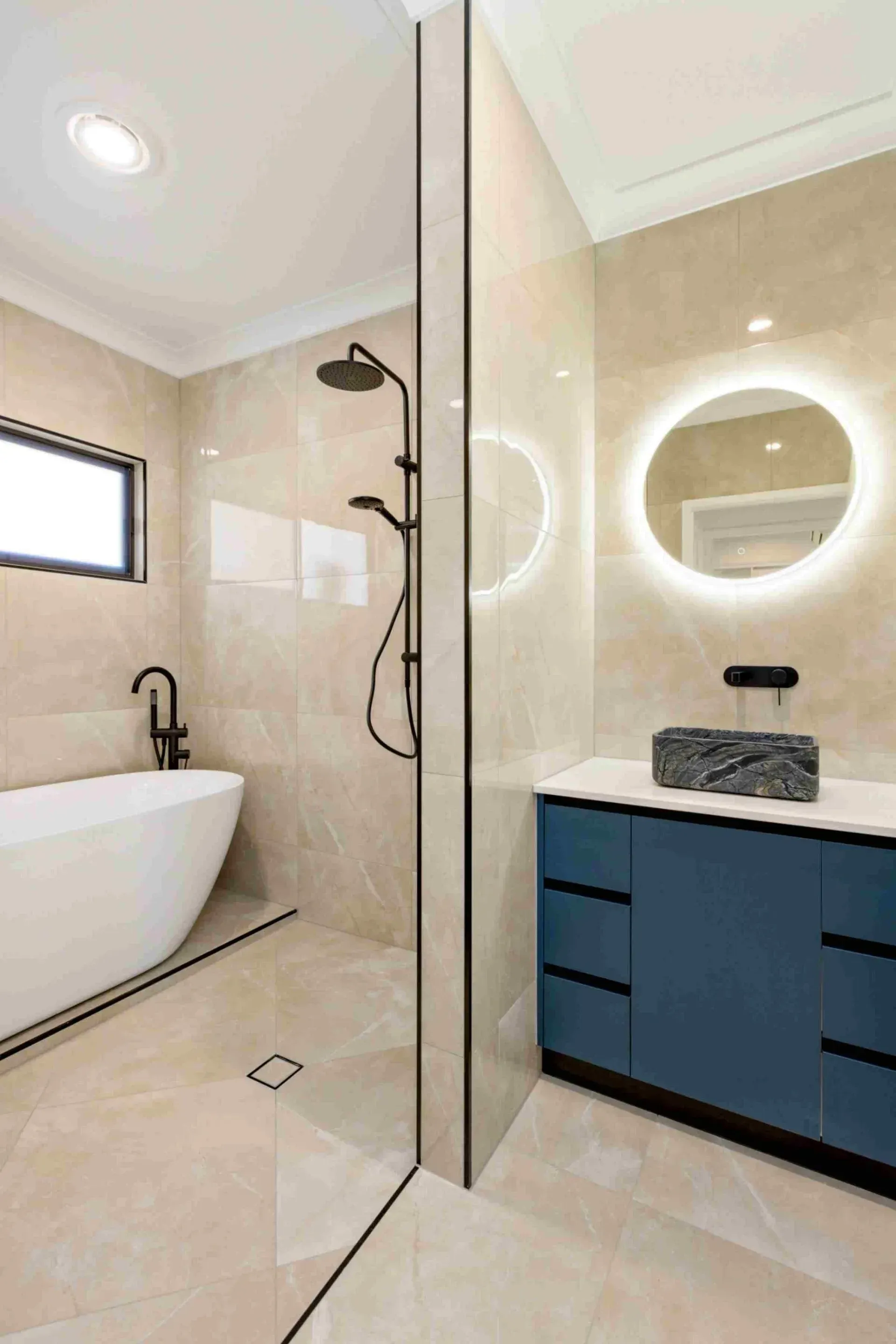 A Bathroom With a Bathtub, Sink, Shower and Mirror — Ashlee Jones Homes in Mission Beach, QLD