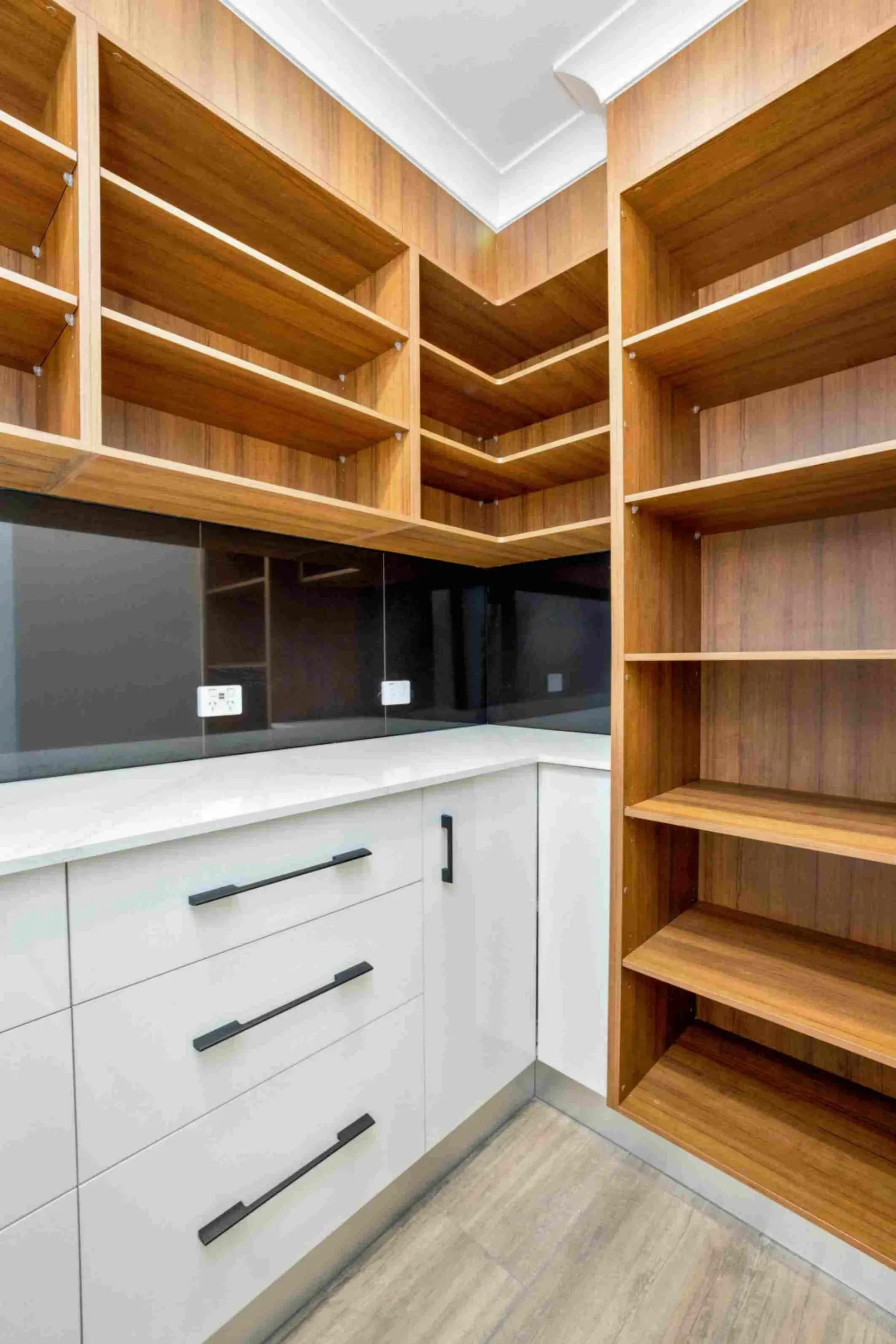A Kitchen With White Cabinets and Wooden Shelves — Ashlee Jones Homes in Gordonvale, QLD