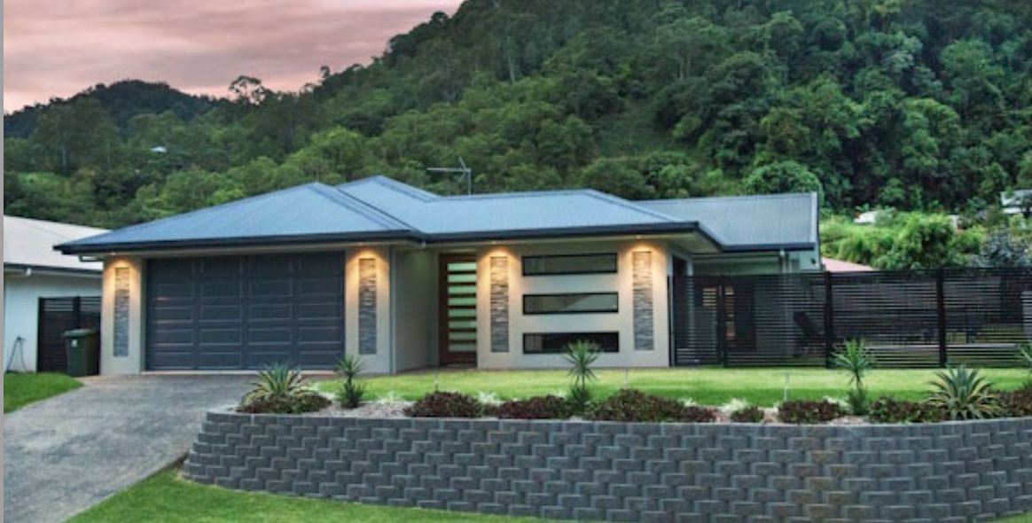 A House With an Orange Garage Door and a Blue Sky in the Background — Ashlee Jones Homes in Gordonvale, QLD