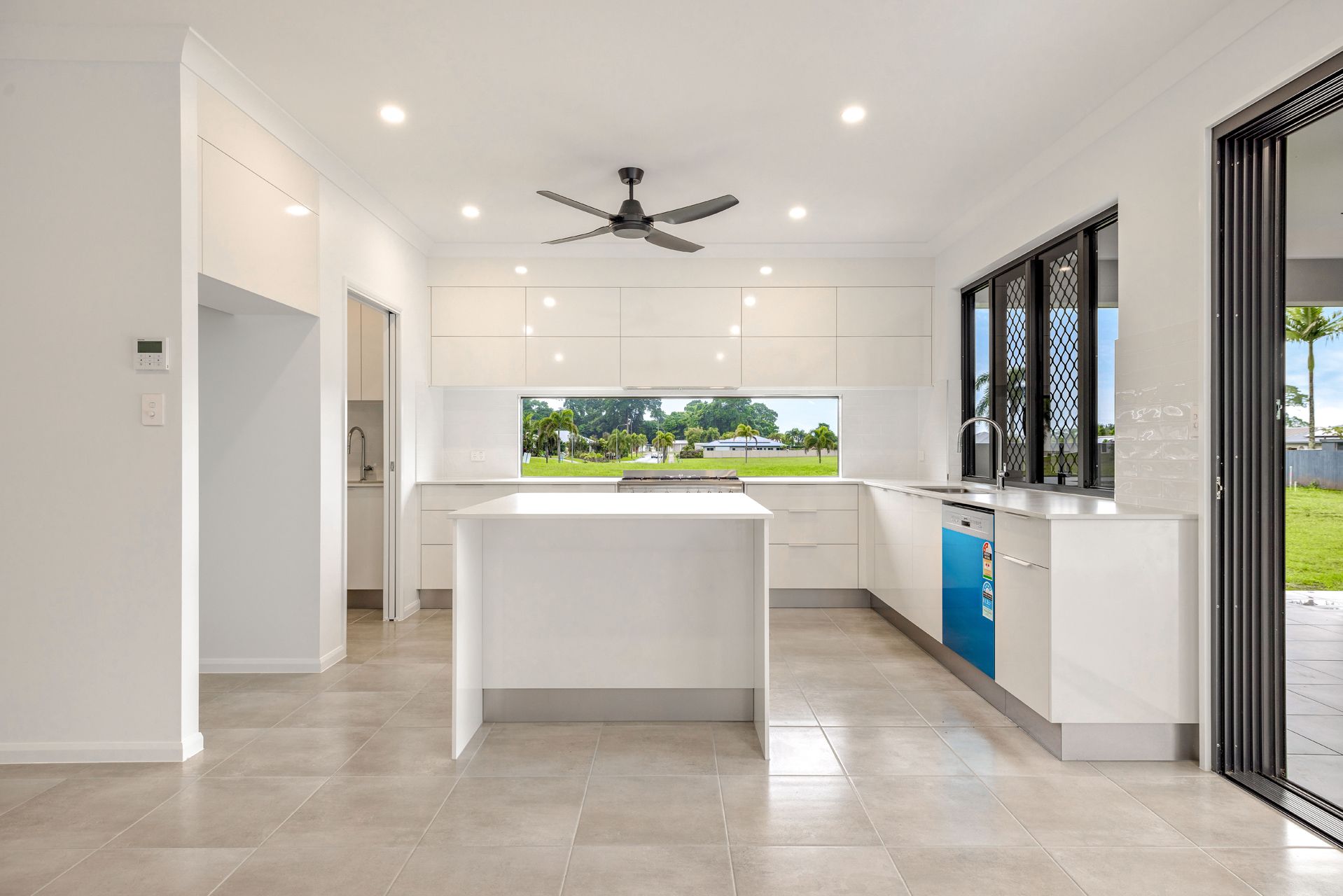 A Modern, Minimalist Kitchen With White Cabinetry — Ashlee Jones Homes in Gordonvale, QLD