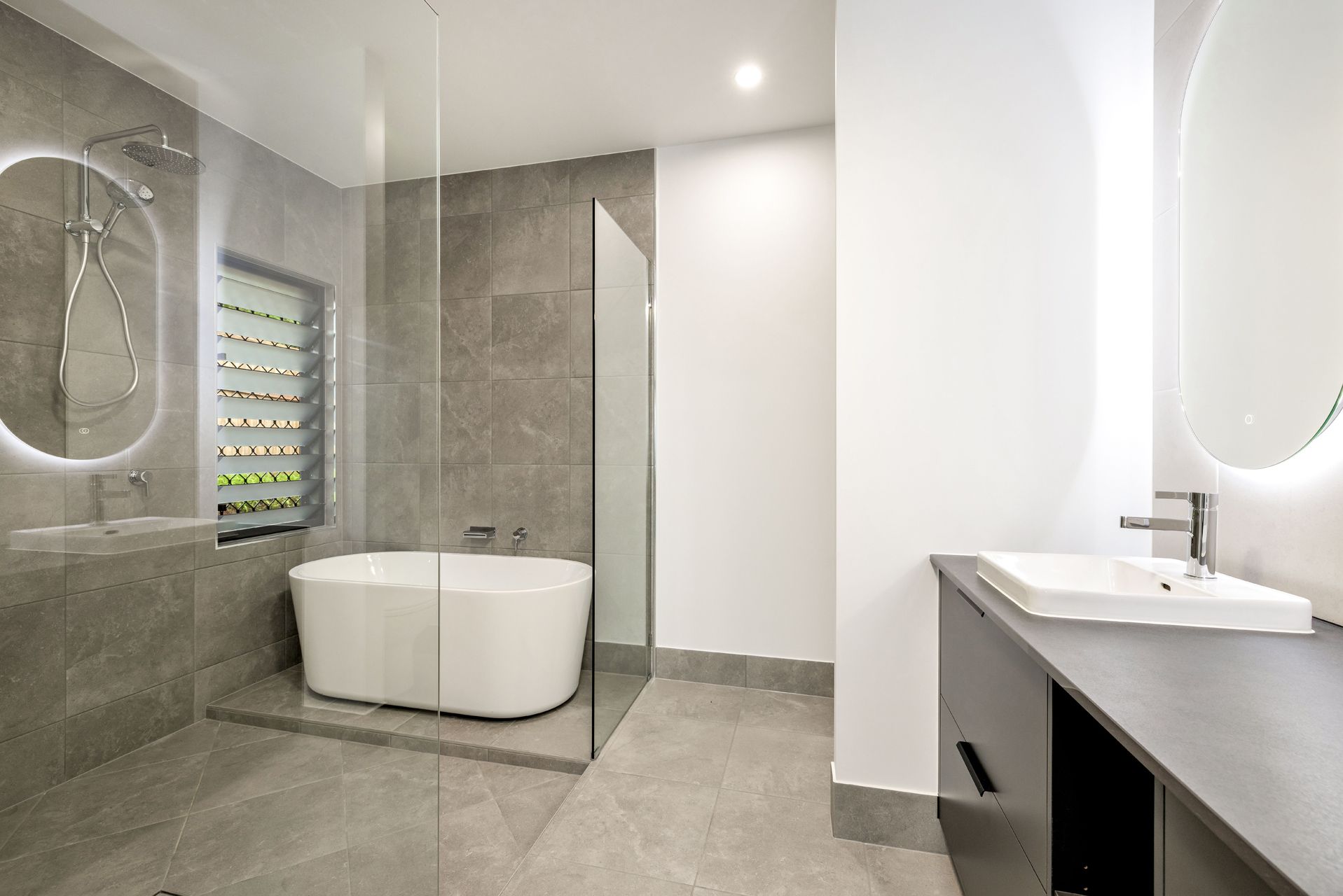 A Modern Bathroom Featuring a White Freestanding Tub — Ashlee Jones Homes in Gordonvale, QLD