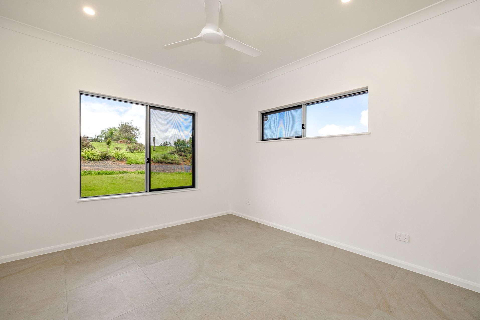 An Empty Room With White Walls, Carpeted Floors — Ashlee Jones Homes in Gordonvale, QLD