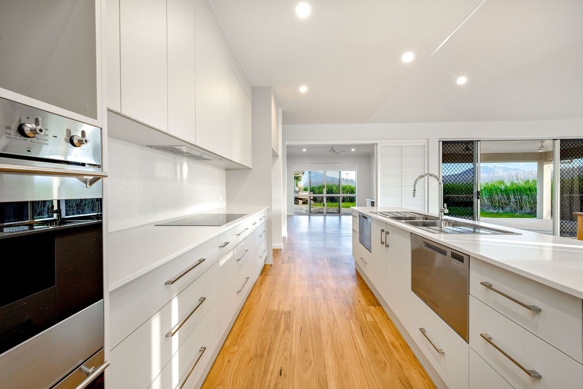 A Modern, Well-lit Kitchen With White Cabinetry — Ashlee Jones Homes in Gordonvale, QLD