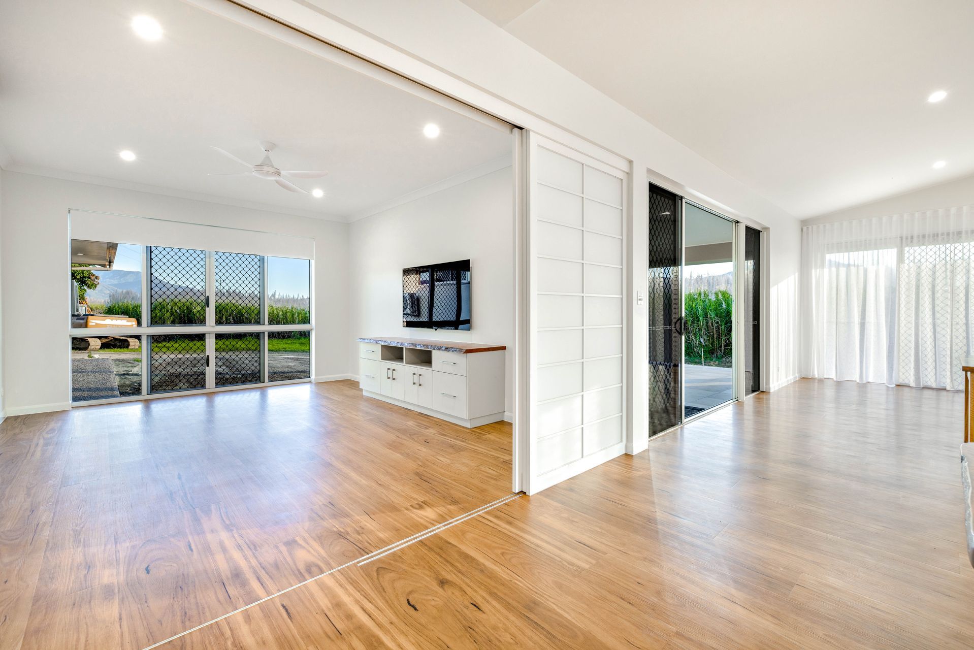 Modern, Open-plan Living Space With Light Wood Flooring — Ashlee Jones Homes in Gordonvale, QLD