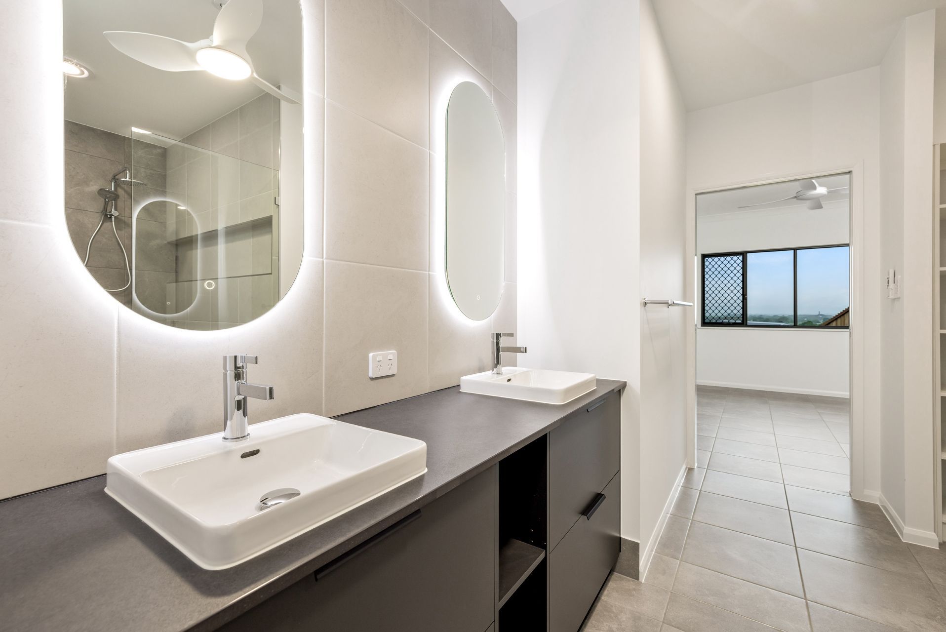 A Modern, Well-lit Bathroom Featuring a Double Vanity With Two Sinks — Ashlee Jones Homes in Gordonvale, QLD