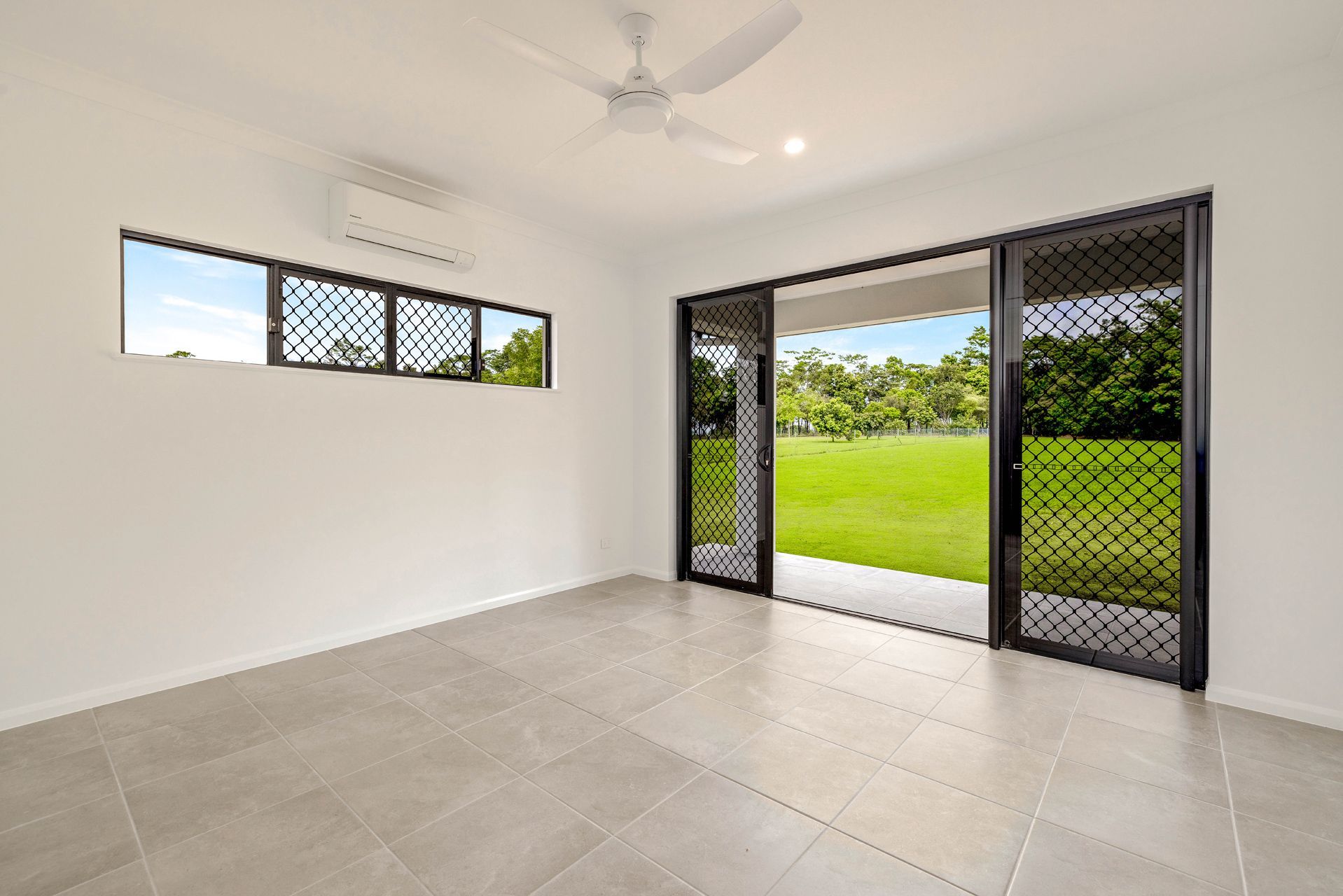An Empty Room With White Walls, Light Gray Tile Floors — Ashlee Jones Homes in Gordonvale, QLD