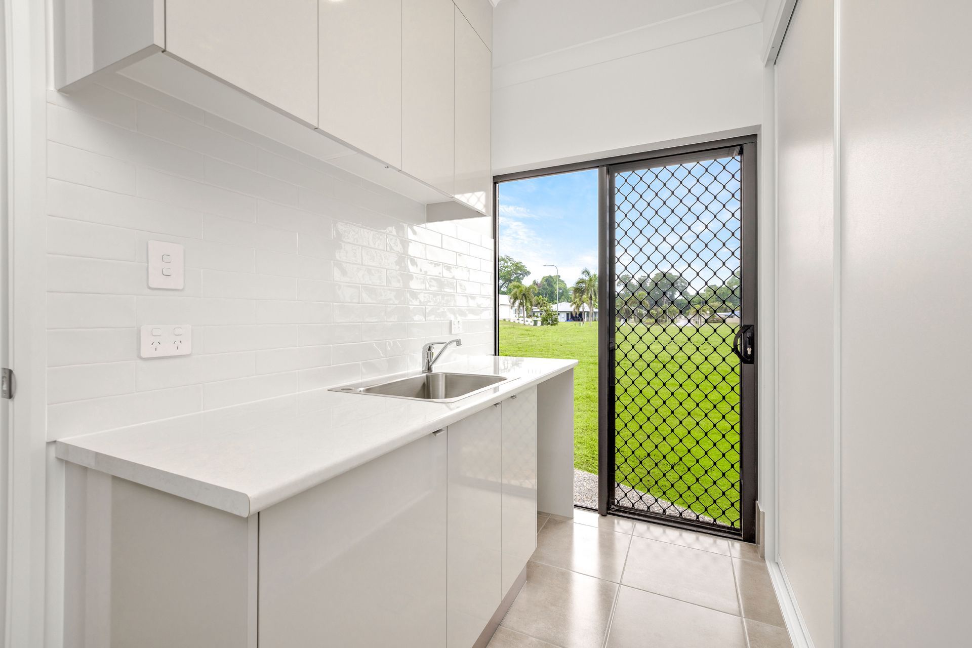 Modern White Kitchen With a Sink, Overhead Cabinets — Ashlee Jones Homes in Gordonvale, QLD