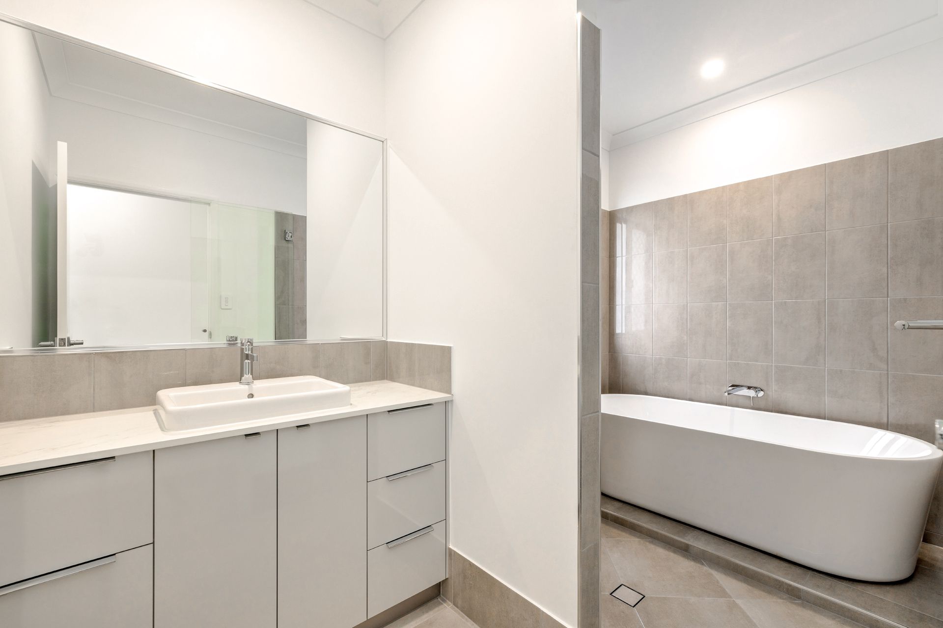 A Modern Bathroom Featuring a White Vanity With a Rectangular Sink — Ashlee Jones Homes in Gordonvale, QLD