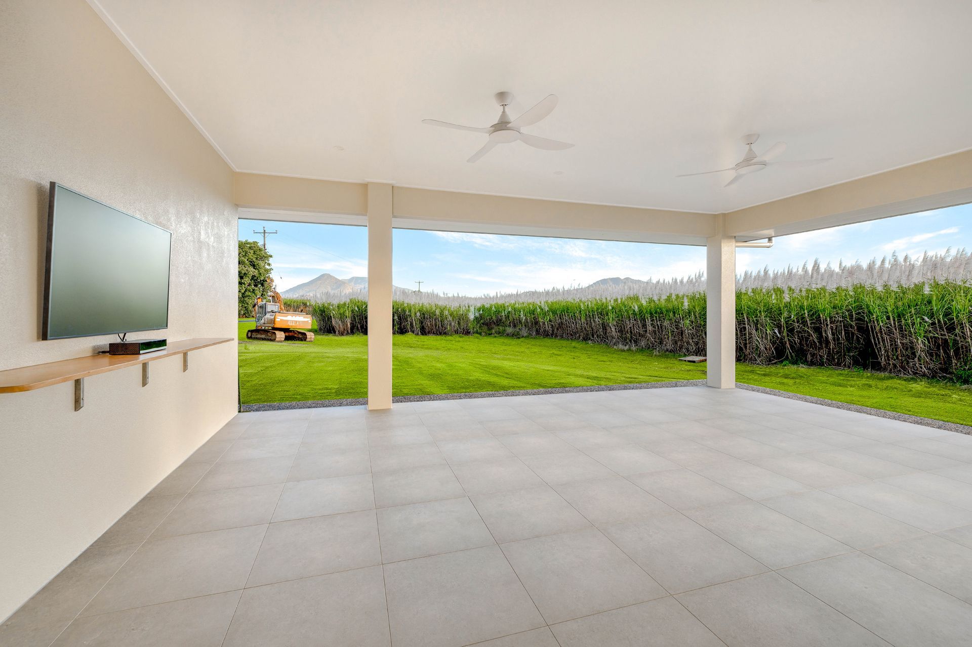 A Spacious, Open-air Patio With Light Gray Tile Flooring — Ashlee Jones Homes in Gordonvale, QLD
