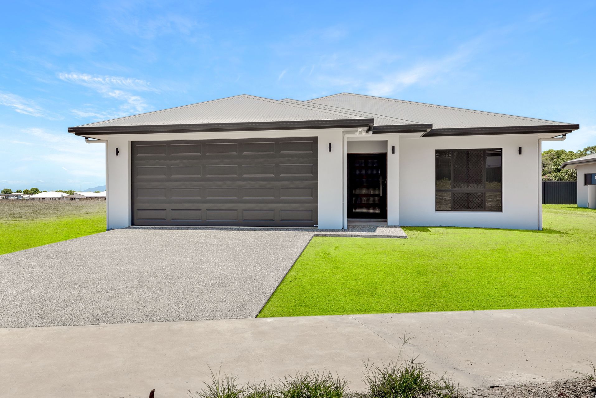 A Modern Single-story Suburban House With a Gray Garage Door — Ashlee Jones Homes in Gordonvale, QLD