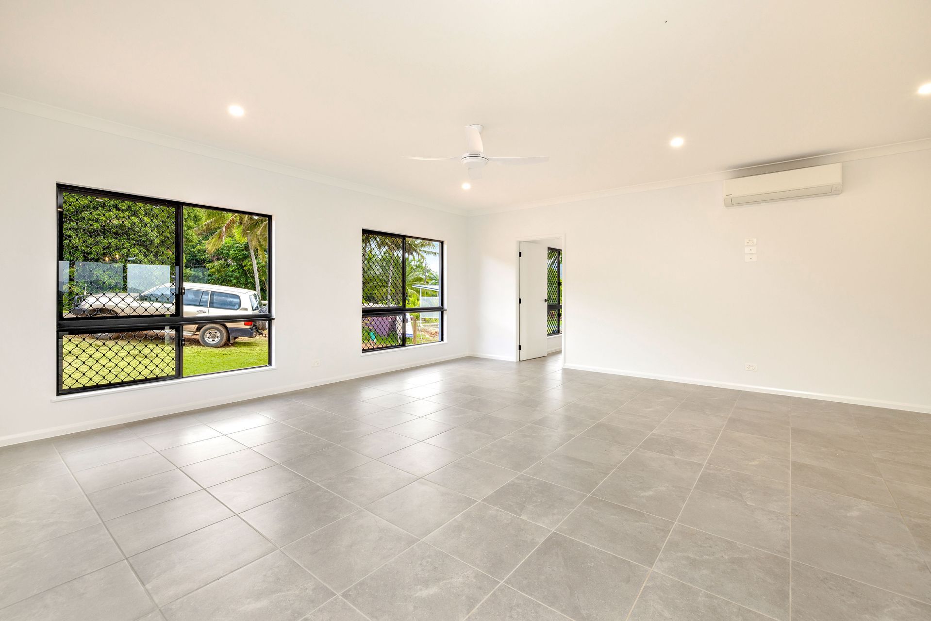 An Empty, Bright Room With White Walls, Large Windows — Ashlee Jones Homes in Gordonvale, QLD
