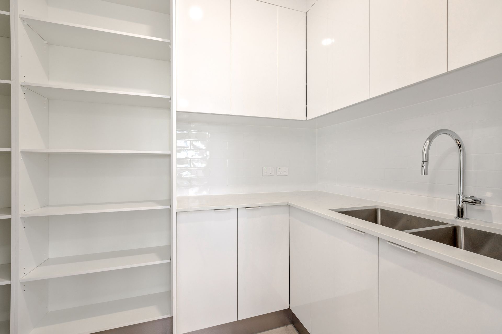 A Modern Kitchen Area Featuring White Cabinets — Ashlee Jones Homes in Gordonvale, QLD